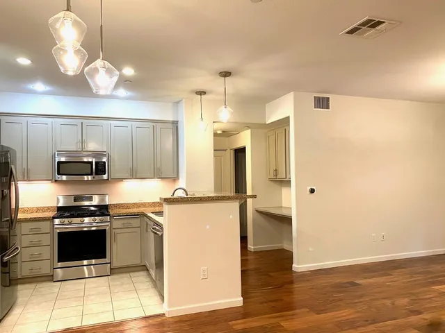 a kitchen with stainless steel appliances a stove a refrigerator and a sink