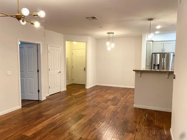 a view of a kitchen with wooden floor and a ceiling fan