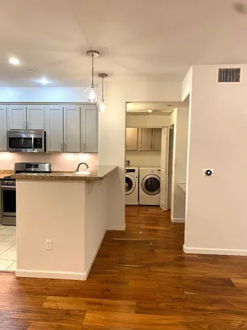 a kitchen with stainless steel appliances granite countertop a sink a stove and a refrigerator