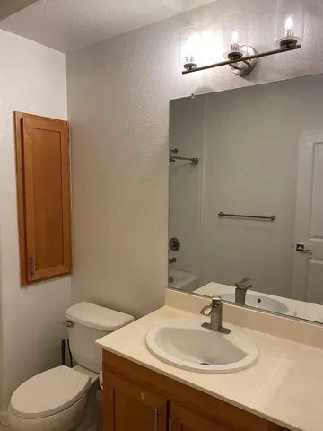a bathroom with a sink a toilet and mirror