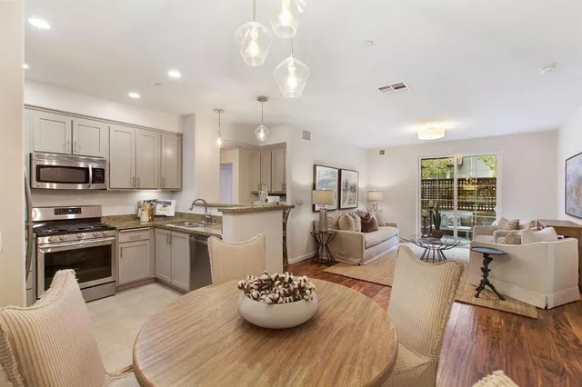 a kitchen with a sink appliances and living room view