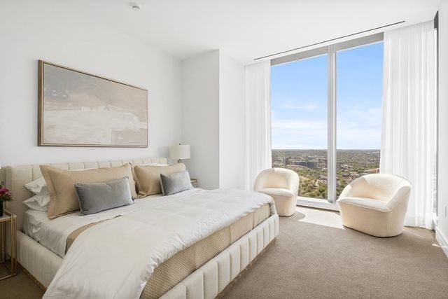 a spacious bedroom with a bed and a large window
