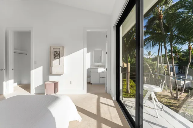 a front view of a house with a yard and potted plants