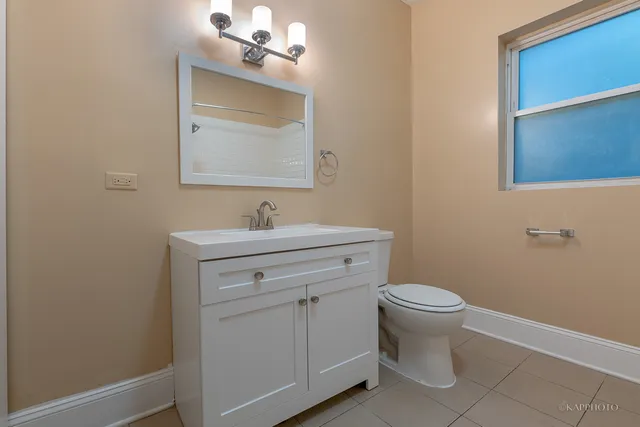 a bathroom with a toilet sink vanity and mirror