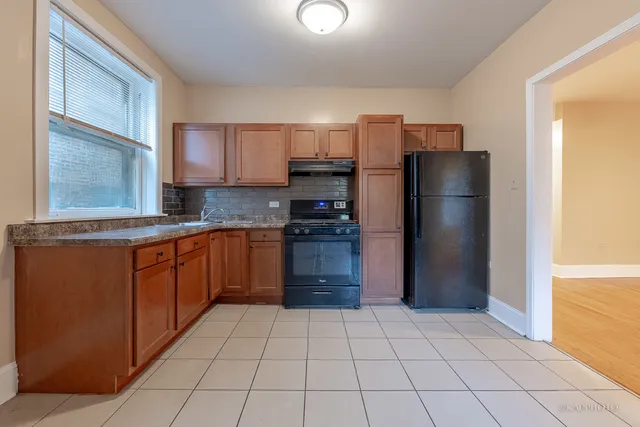 a kitchen with stainless steel appliances granite countertop a refrigerator and a stove top oven