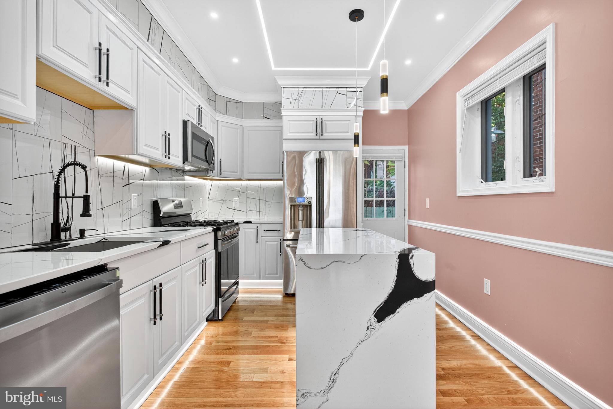 5421 Kingsessing Avenue Philadelphia, PA 19143 - Photo 14 of 39 a kitchen with stainless steel appliances granite countertop a sink and cabinets