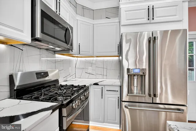 a kitchen with stainless steel appliances a refrigerator sink and cabinets