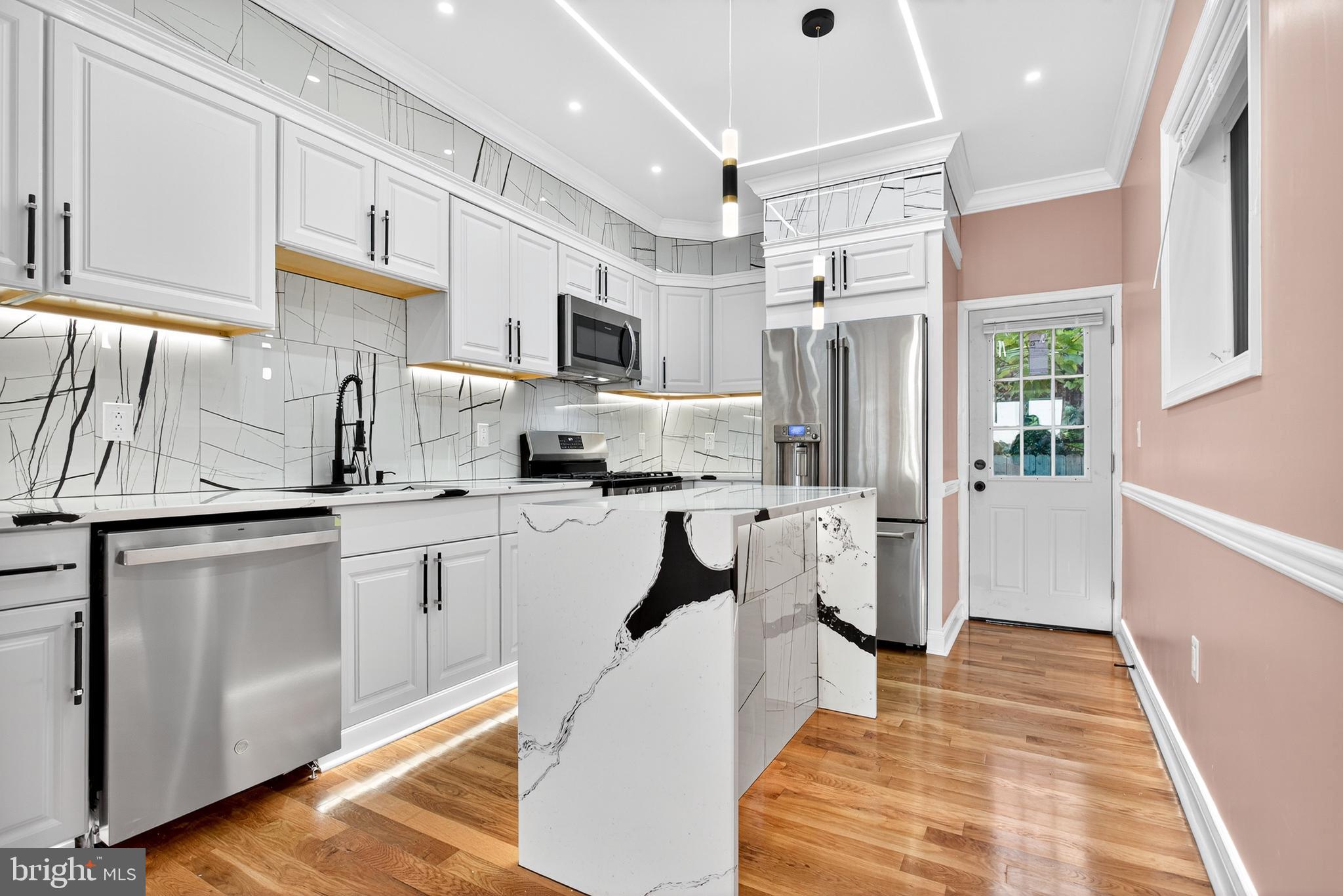 5421 Kingsessing Avenue Philadelphia, PA 19143 - Photo 17 of 39 a kitchen with stainless steel appliances a refrigerator sink and cabinets