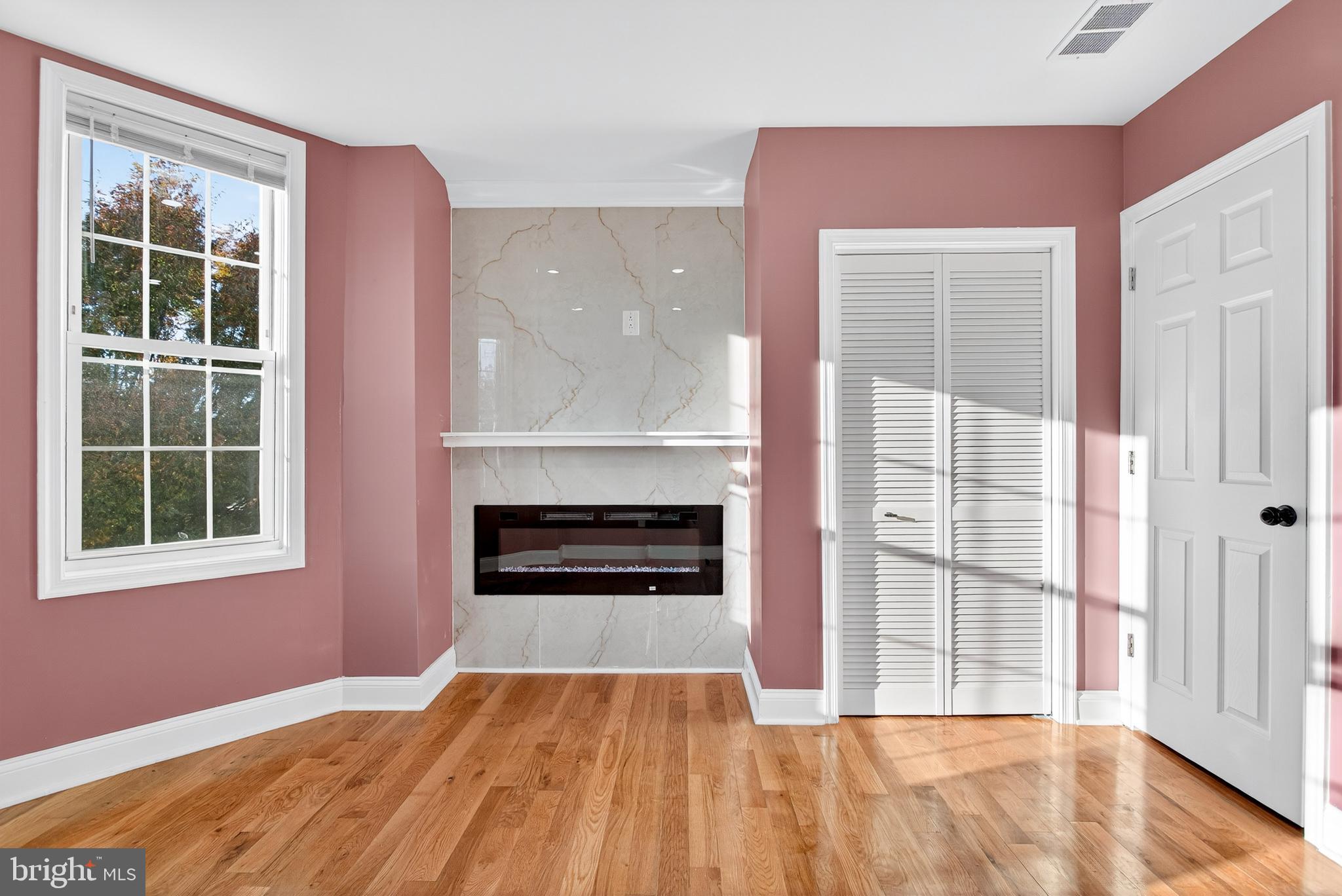 5421 Kingsessing Avenue Philadelphia, PA 19143 - Photo 21 of 39 wooden floor fireplace and windows in an empty room