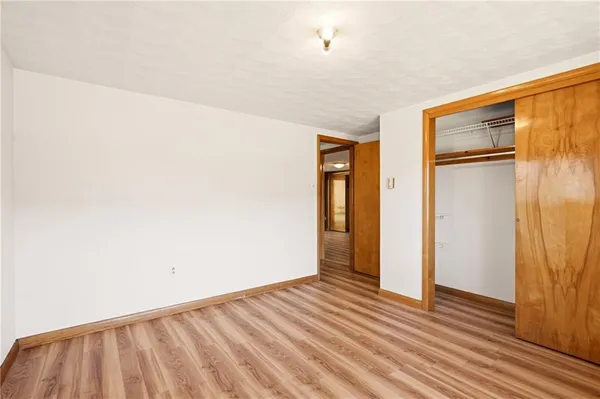 a spacious bedroom with a bed and a lamp