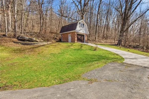a view of a house with large trees and a yard
