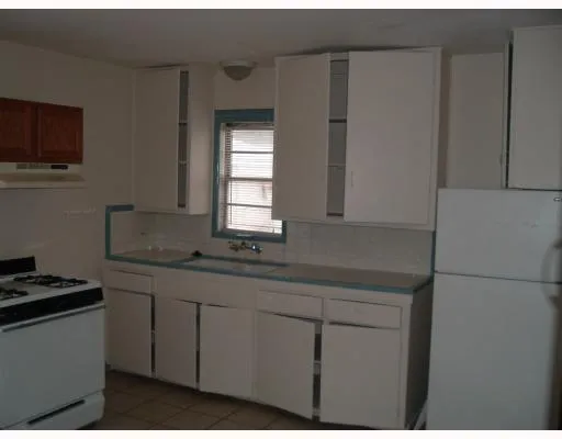 a kitchen with stainless steel appliances white cabinets and a window
