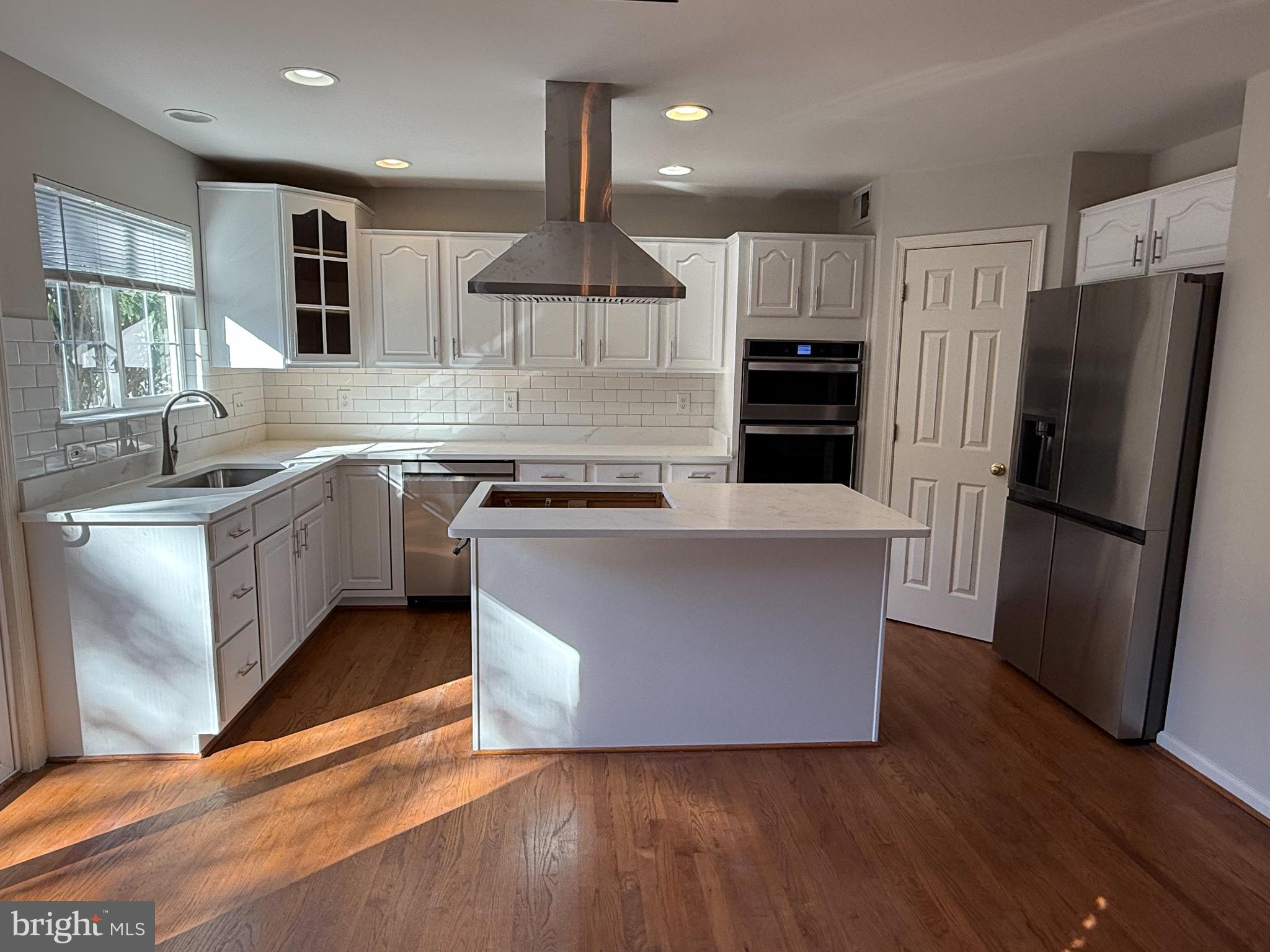 20453 Charter Oak Drive Ashburn, VA 20147 - Photo 3 of 31 a large kitchen with stainless steel appliances granite countertop a stove a refrigerator a sink a microwave and wooden floor
