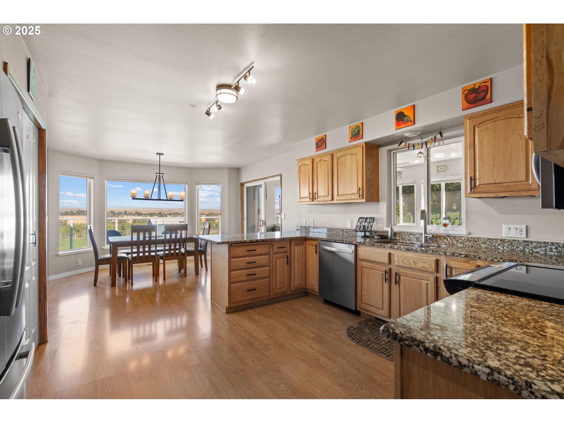 75077 Oregon Lane Irrigon, OR 97844 - Photo 9 of 41 a kitchen with granite countertop a stove a sink a dining table and chairs