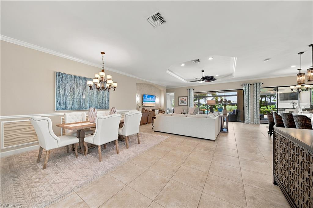 9256 Rialto Lane Naples, FL 34119 - Photo 16 of 43 Formal dining area featuring wainscoting and crown molding, tile flooring, and a chandelier
