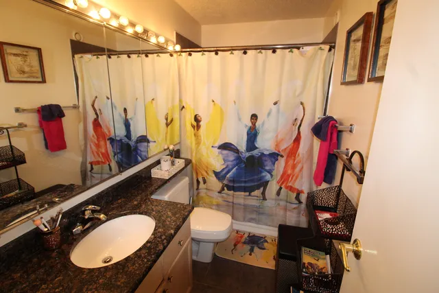 a bathroom with a sink mirror vanity and toilet