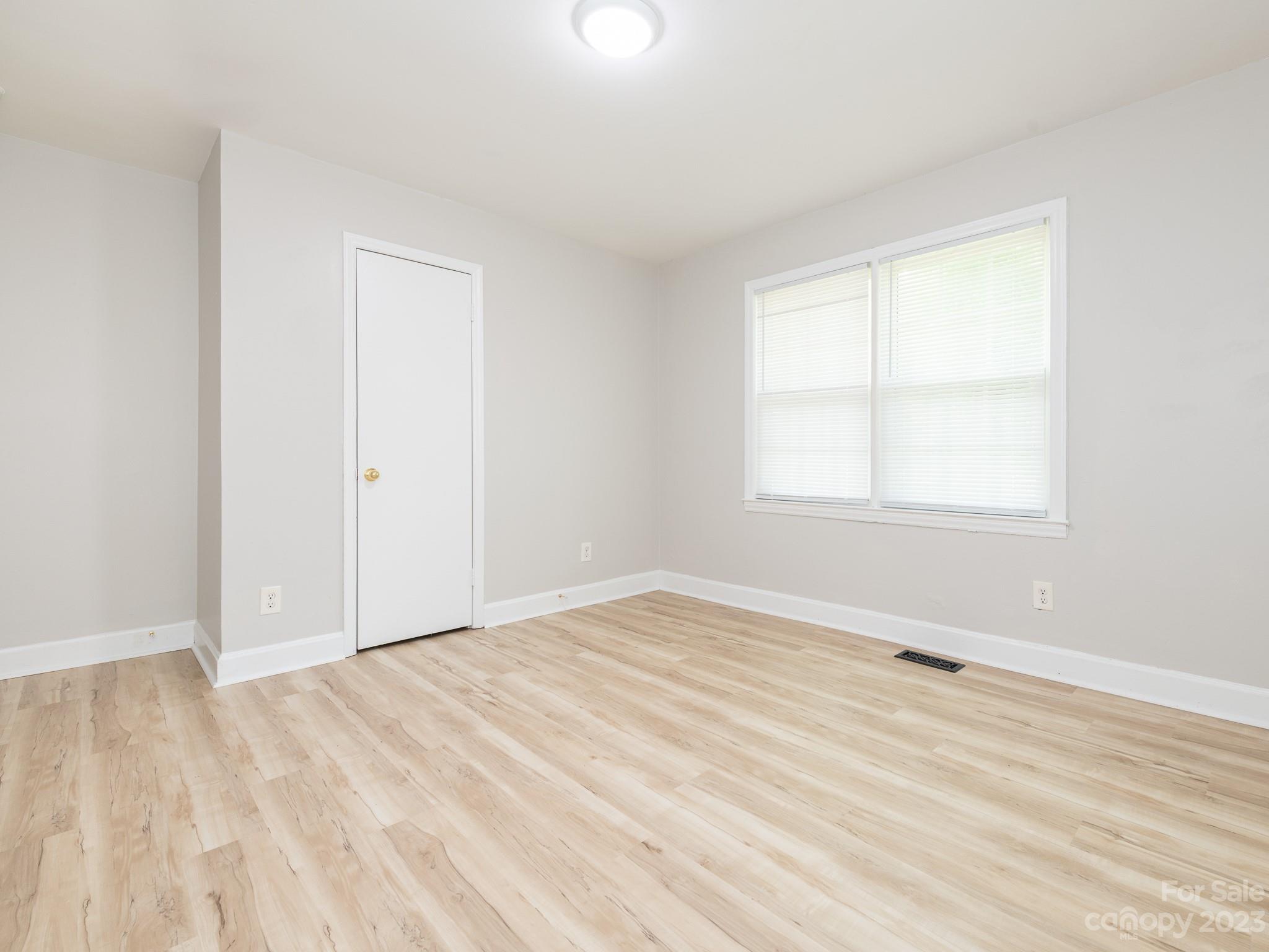 2824 Fordwood Drive Charlotte, NC 28208 - Photo 19 of 33 a view of an empty room with wooden floor and a window