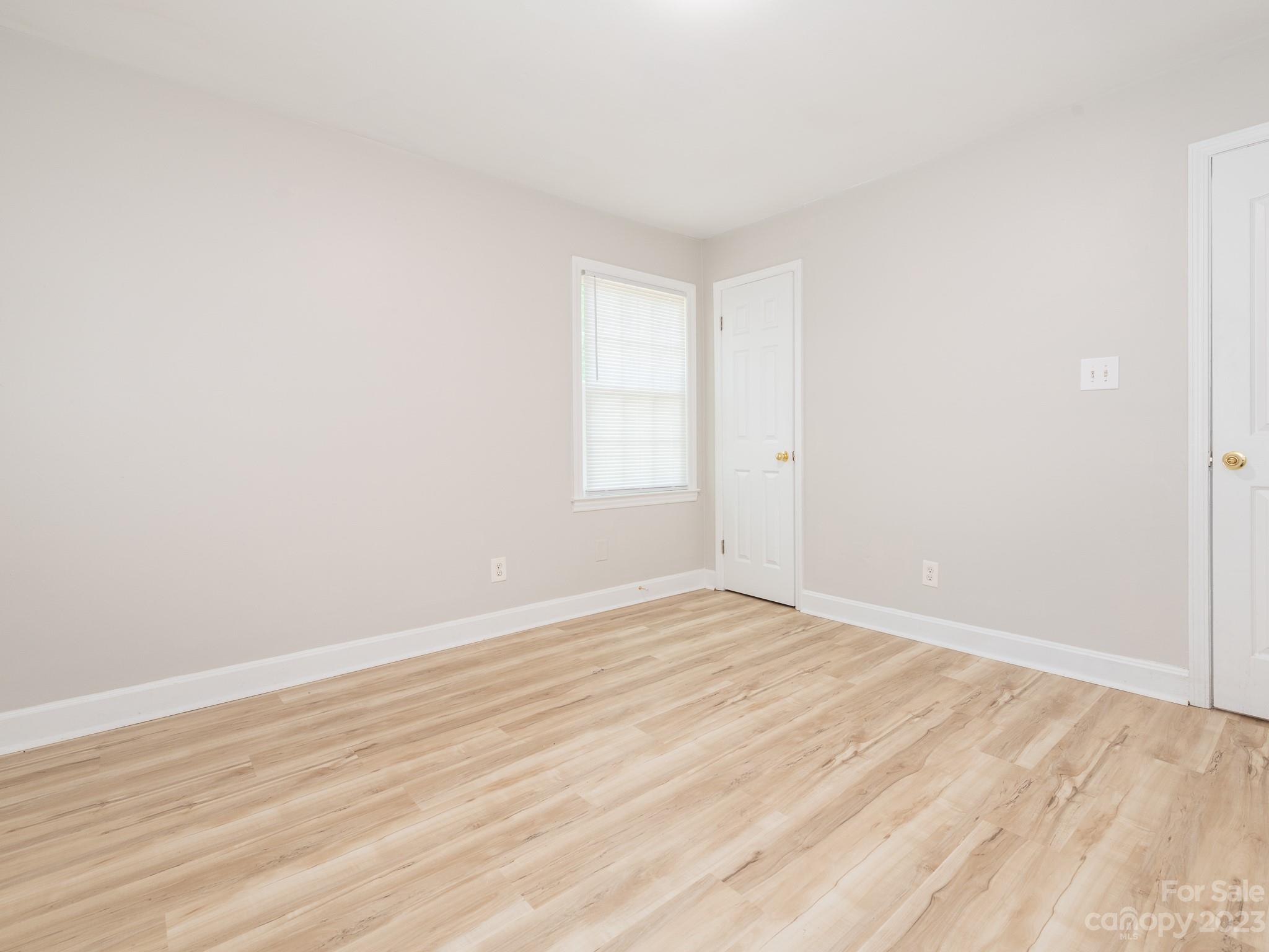 2824 Fordwood Drive Charlotte, NC 28208 - Photo 20 of 33 an empty room with wooden floor and windows