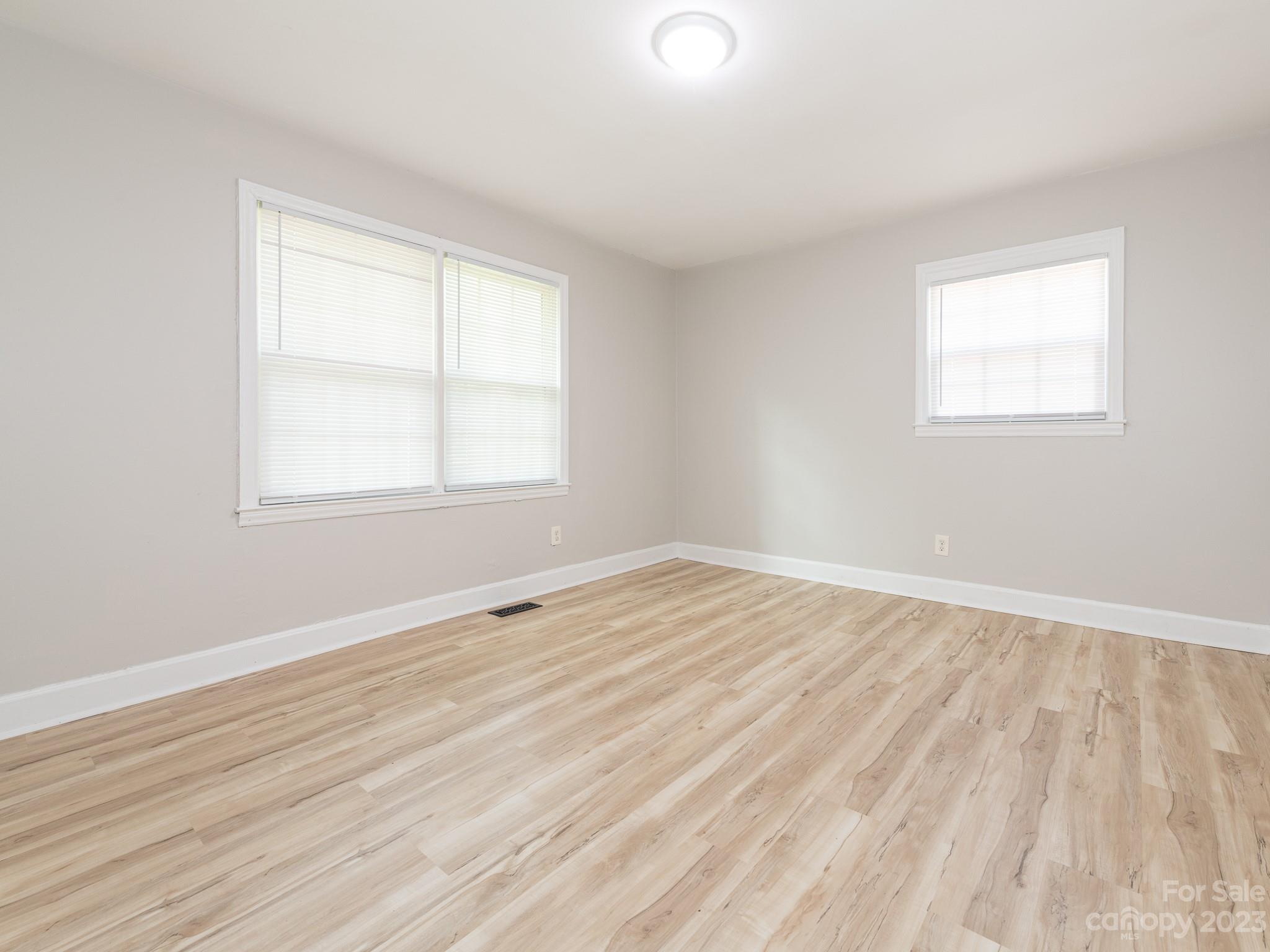 2824 Fordwood Drive Charlotte, NC 28208 - Photo 5 of 33 an empty room with wooden floor and windows