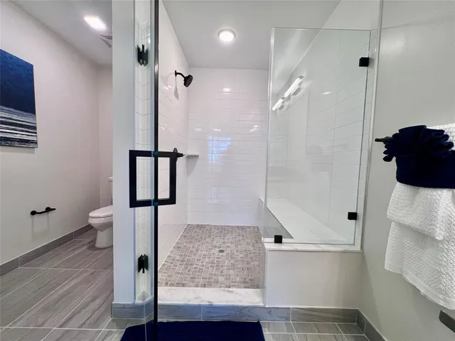 a bathroom with a glass shower door a sink and a shower