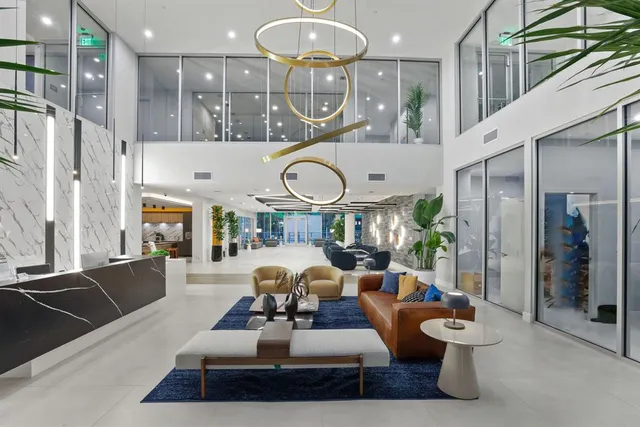 a living room with furniture a rug and kitchen view