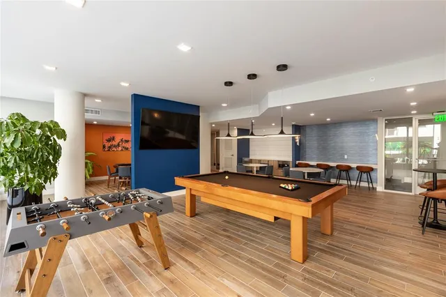 a living room with furniture a flat screen tv and a table