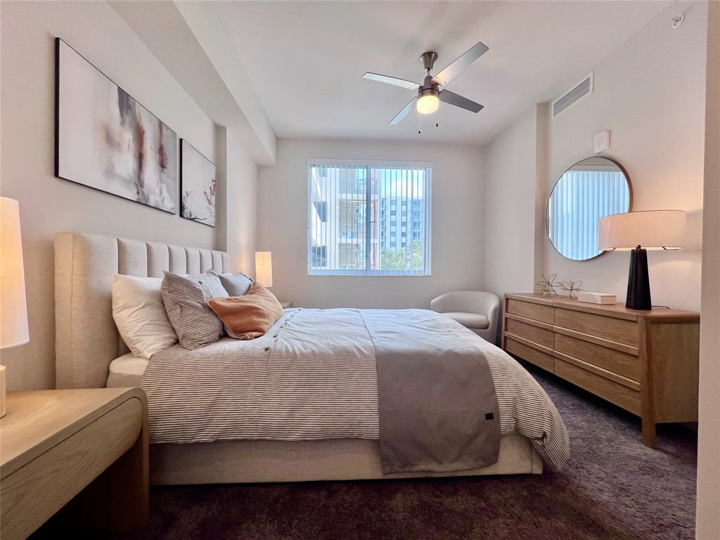 120 North Compass Way, Unit 230 Dania Beach, FL 33004 - Photo 10 of 42 a bedroom with bed and a chandelier