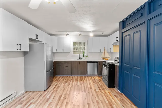 a kitchen with a refrigerator and wooden cabinets
