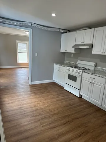 a kitchen with a wooden floor and a stove top oven