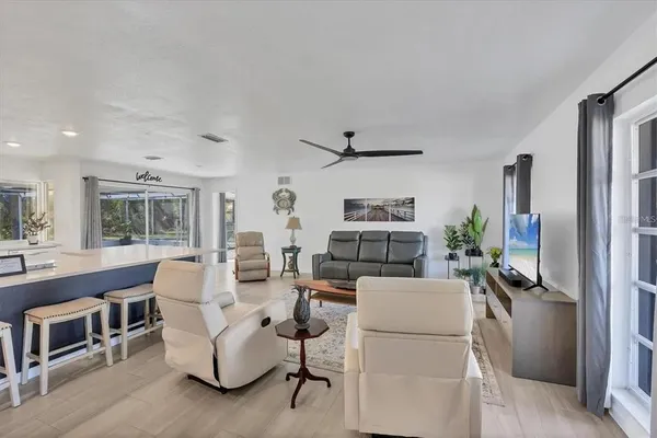 a living room with furniture a flat screen tv and a table