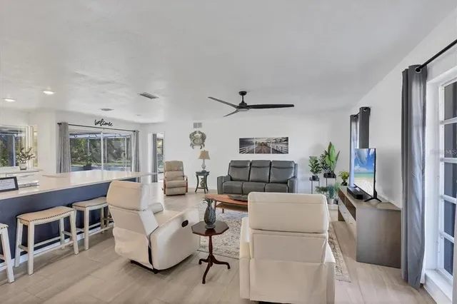 a living room with furniture a flat screen tv and a table