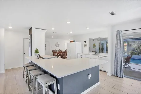 a kitchen with kitchen island a sink table and chairs
