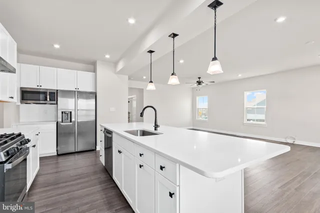 a view of a kitchen with stainless steel appliances granite countertop a sink a refrigerator and a stove