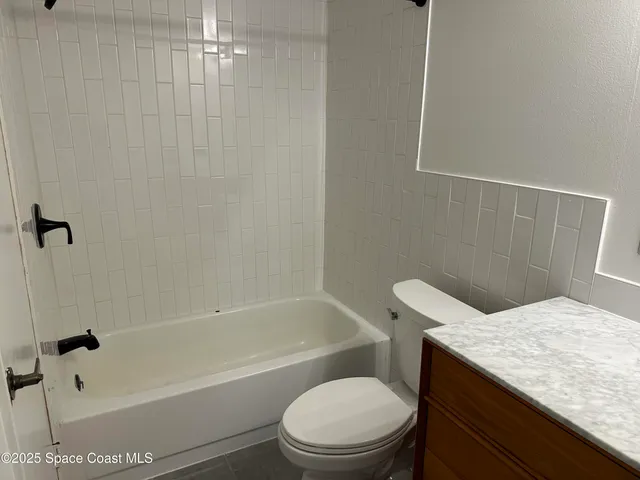 a bathroom with a granite countertop sink toilet and mirror