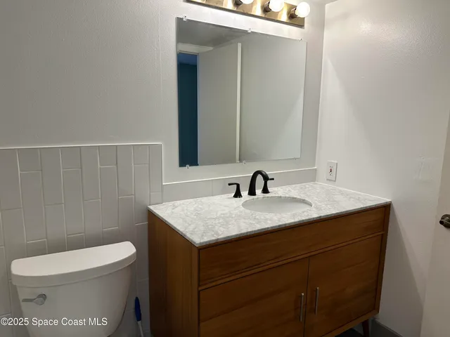 a view of a hallway with wooden floor and closet
