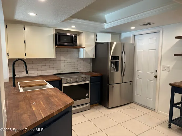 a kitchen with stainless steel appliances granite countertop a refrigerator and a sink