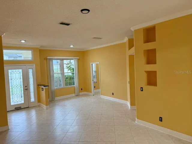 a view of an empty room with glass door and balcony