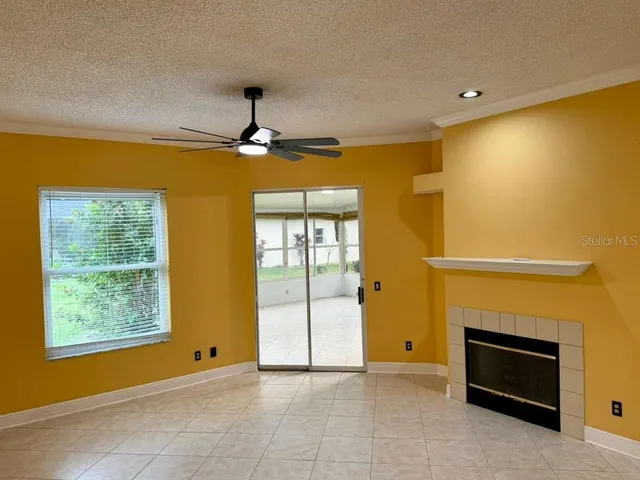 a view of an empty room with a fireplace and a window