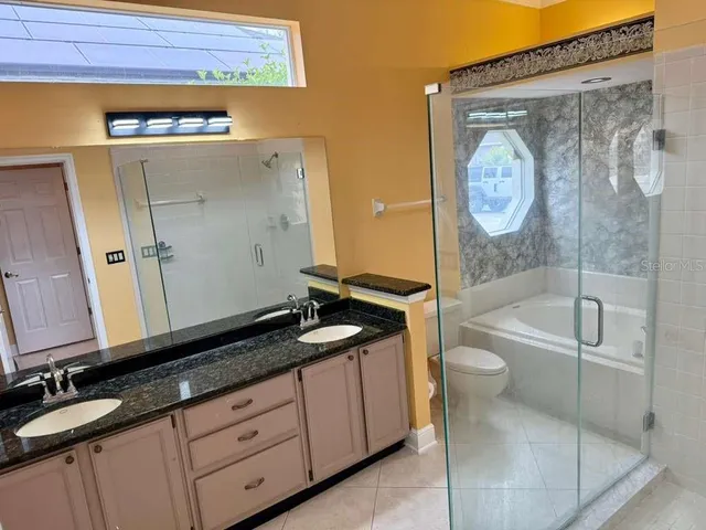 a bathroom with a granite countertop sink toilet and shower