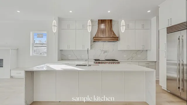 a kitchen with kitchen island granite countertop a sink a stove a refrigerator and white cabinets