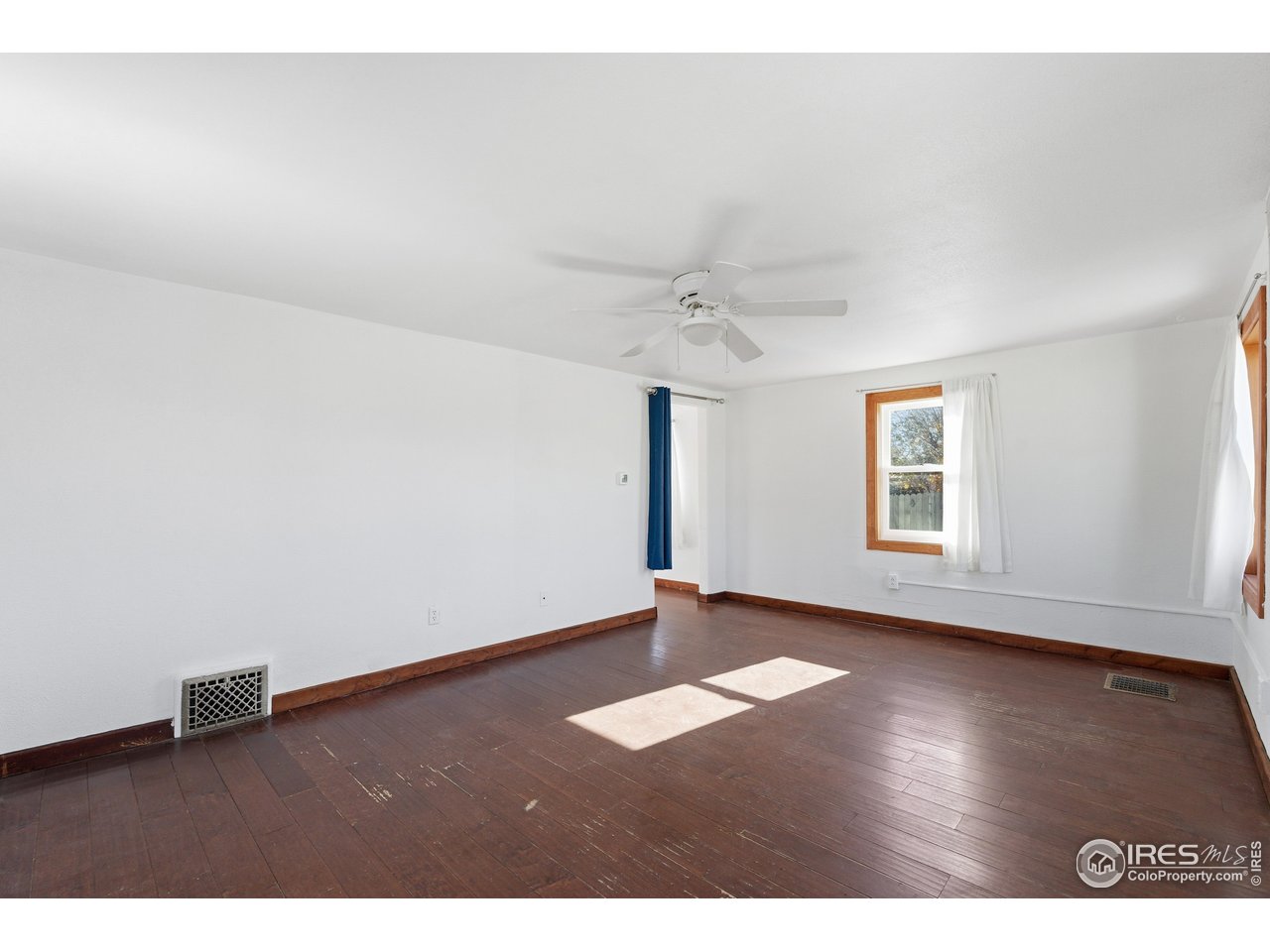 2706 7th Avenue Garden City, CO 80631 - Photo 5 of 47 an empty room with wooden floor and windows