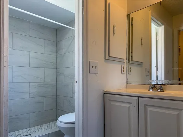a bathroom with a granite countertop sink toilet and shower