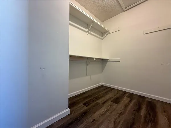 a view of a room with wooden floor and cabinets