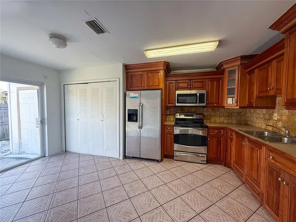 a kitchen with stainless steel appliances granite countertop a refrigerator and a stove top oven