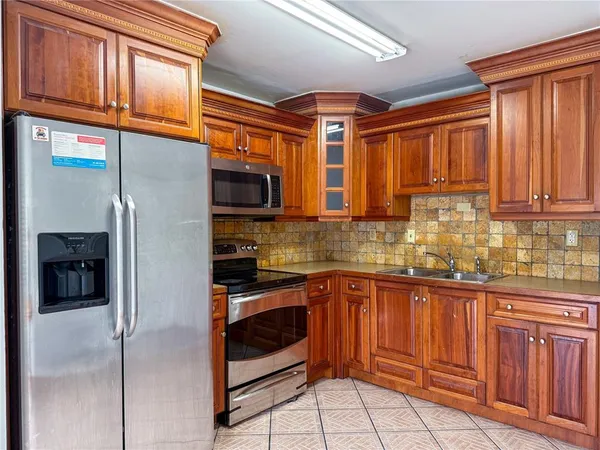 a kitchen with stainless steel appliances granite countertop a refrigerator and a sink