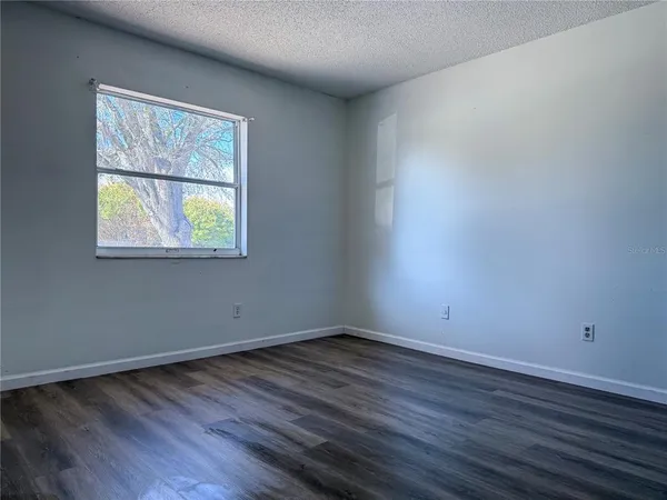 an empty room with wooden floor and a window