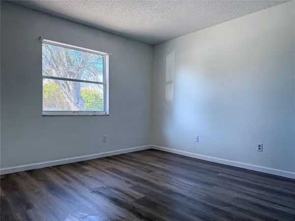 an empty room with wooden floor and a window