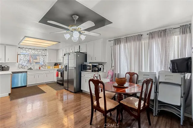 a kitchen with a dining table chairs and refrigerator