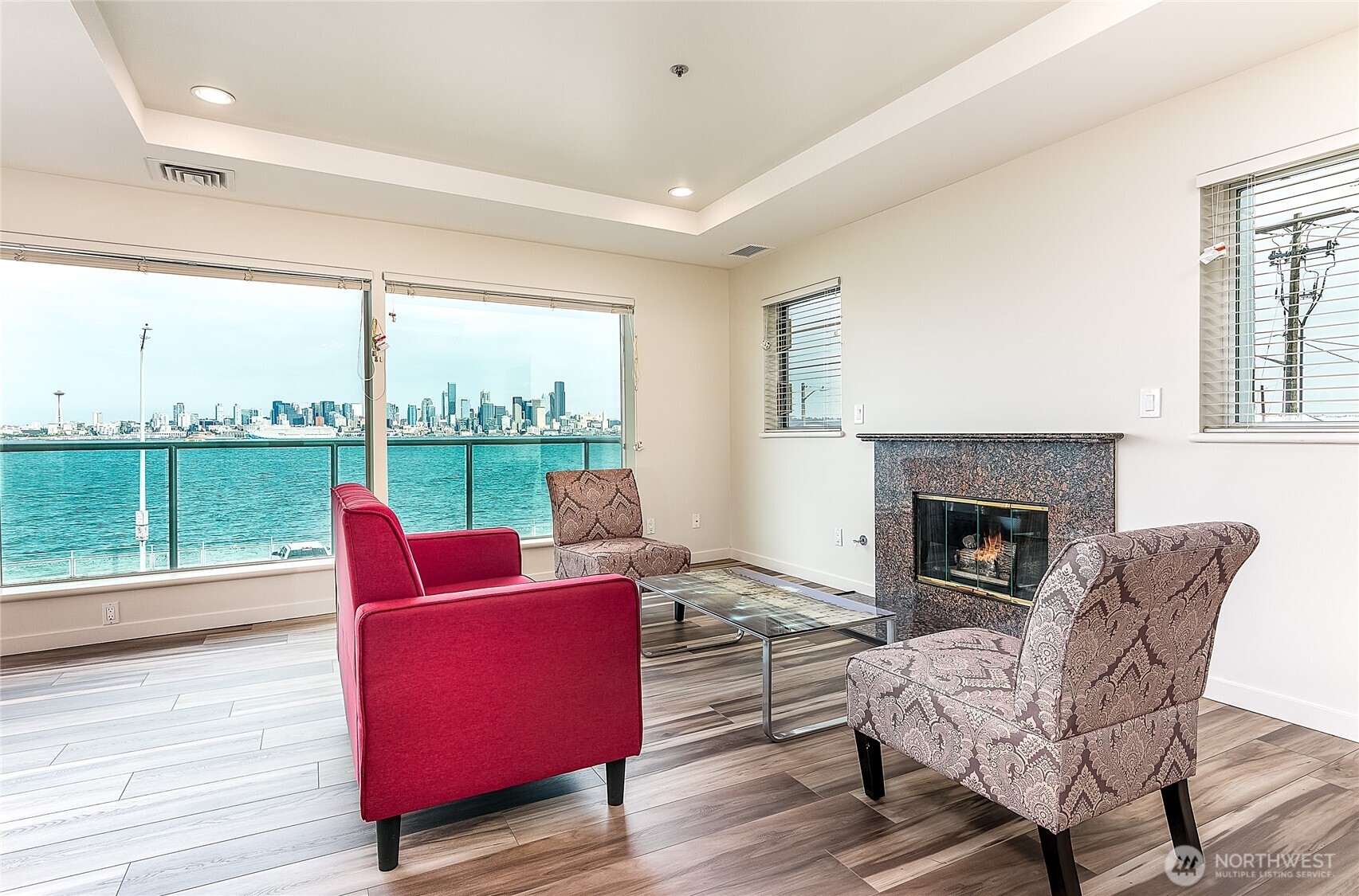 1027 Harbor Avenue Southwest, Unit 303 Seattle, WA 98116 - Photo 11 of 20 a living room with furniture a fireplace and a floor to ceiling window