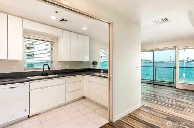 a kitchen with granite countertop a sink and white cabinets